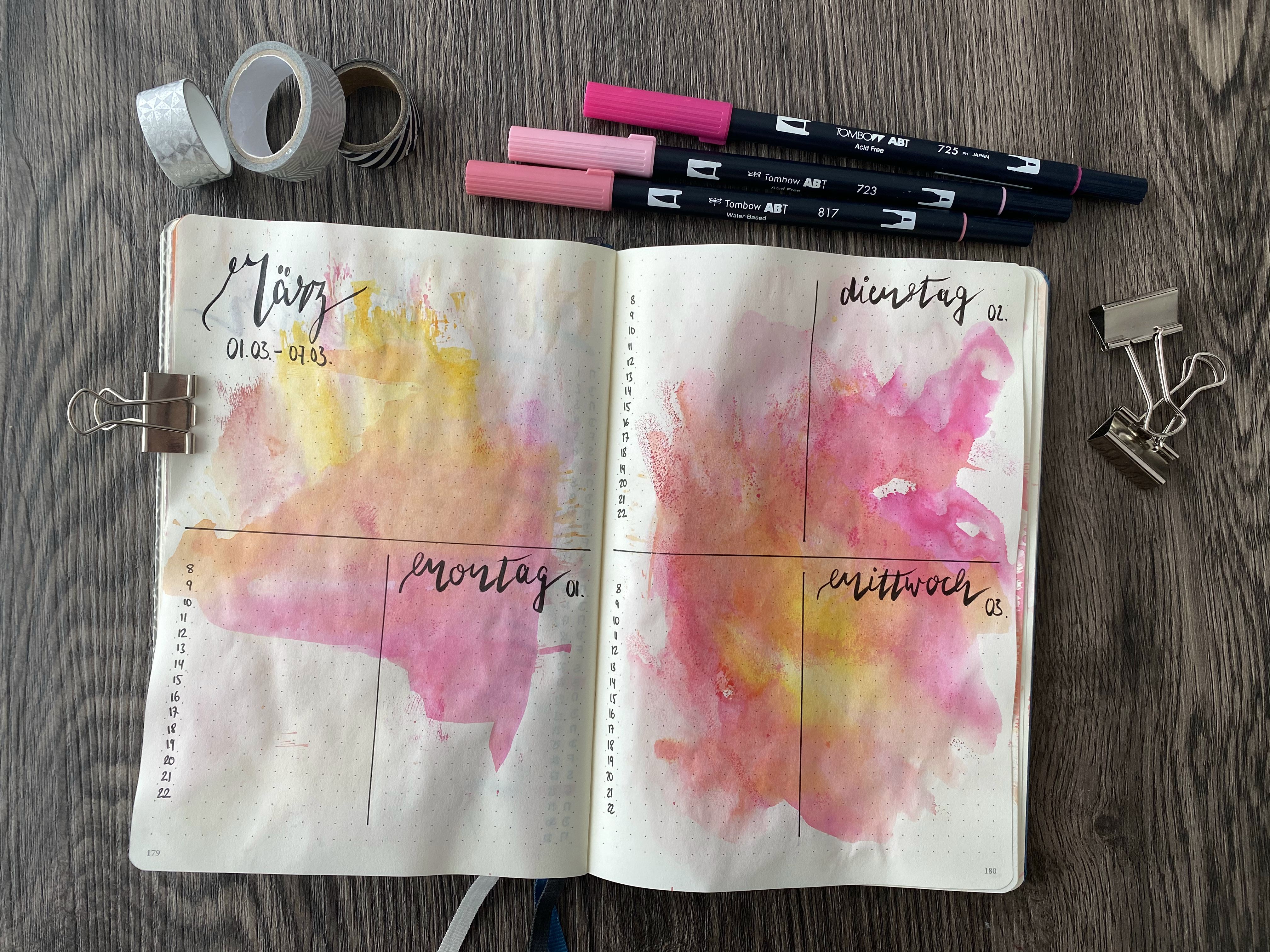 Aufgeschlagenes Bullet Journal mit Wochenübersicht in Pink und Gelb